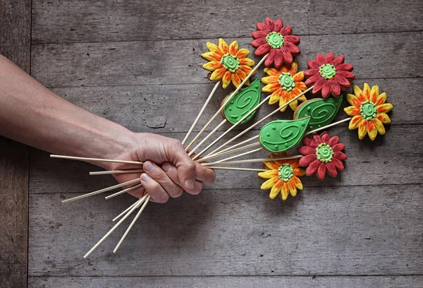 Iemands Hand Met Een Boeket Van Peperkoek Bloemen Rustieke Houten — Stockfoto