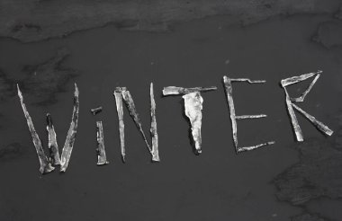 Söz, buz saçaklarından siyah arkaplandaki karla ıslanmış saçaklardan geldi. Sezon konsepti. 