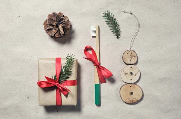 Sıfır atık plastiksiz noel hediyesi düz yatak. Bambu diş fırçası, hediye paketi, el yapımı Xmas doğal dekorasyon. Dikkatli tüketim kavramı. Çevre dostu yaşam tarzı.