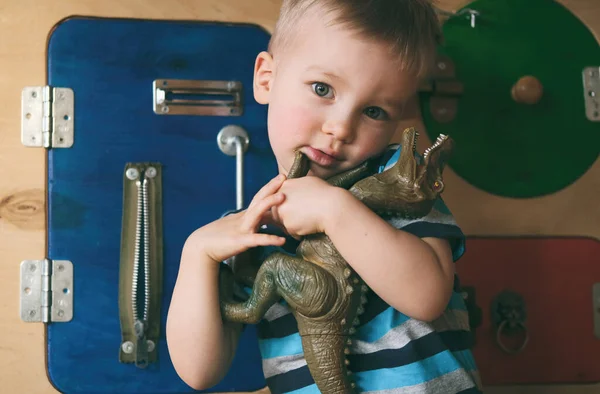 Portret Van Een Schattig Klein Jongetje Knuffelende Speelgoeddinosaurus Een Drukke — Stockfoto