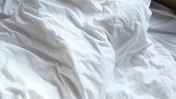 穿着蓝色睡衣的可爱而快乐的小男孩在床上醒来 又伸展着身子躲在毯子下 — 图库视频影像