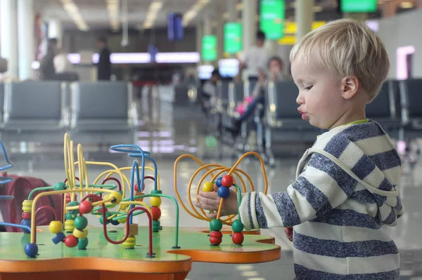 Lindo Niño Jugando Sala Juegos Pública Terminal Del Aeropuerto Mientras Imagen de archivo