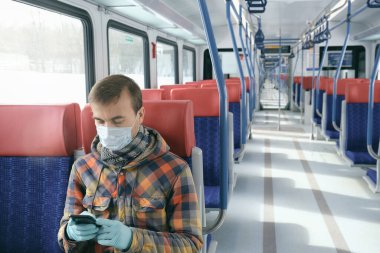 Hastalık salgını, Coronavirus covid-19 salgını, virüs koruması, karantina. Tıbbi koruyucu maskeli ve eldivenli yetişkin bir adam akıllı telefon kullanıyor.. 
