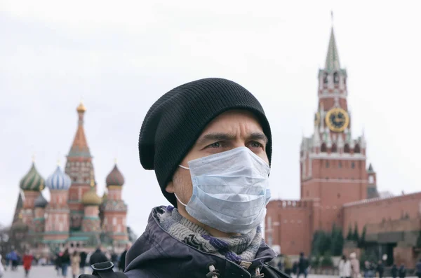 Hastalık salgını, Coronavirus covid-19 salgını, Moskova, Rusya 'da hava kirliliği. Tıbbi koruyucu maskeli yetişkin bir adamın portresi Kremlin ve Kızıl Meydan arka planda. 