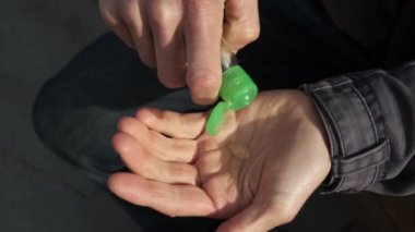 Adam, virüsü önlemek için yemeden önce sokaklarda susuz alkol bazlı antiseptik jelle el temizliyor. Yolda sabun yıkamaya alternatif. Seyahatte kişisel temizlik..