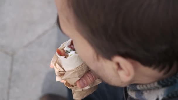 满嘴胡须的高加索人在城市街道上吃素食快餐 商人在外面与多纳烤面包或猎鹰沙拉或玉米饼三明治共进午餐 从上面看 — 图库视频影像