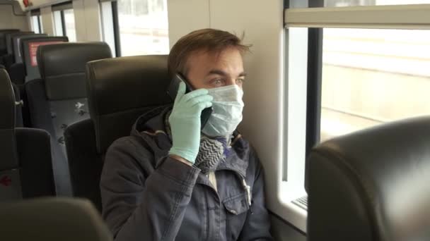 戴着医疗防护面具和手套的成年高加索男子坐在公共交通工具内 用智能手机交谈 疾病爆发 眼镜蛇 19大流行病 预防流行病 — 图库视频影像