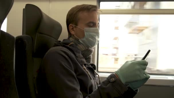 身穿医疗防护面具和手套的成年高加索男子坐在公共交通工具内 使用智能手机 疾病爆发 眼镜蛇 19大流行病 预防流行病 个人卫生 — 图库视频影像