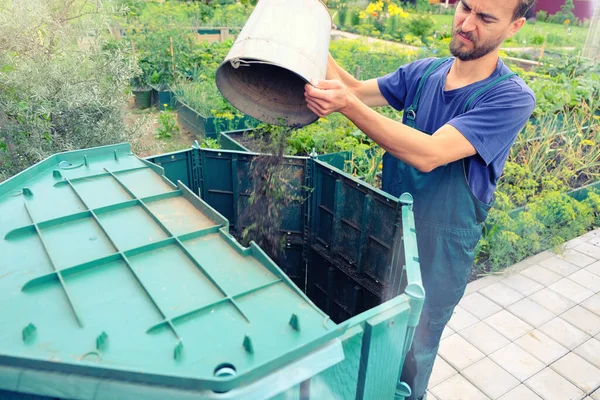 農家は彼の庭から雑草や有機性廃棄物を堆肥のヒープに投げます 堆肥化 環境に優しいリサイクル技術 有機栽培の庭 持続可能な食品 ストック画像