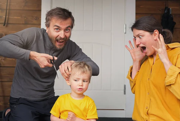 Family haircut at home during quarantine, domestic hairdressers. Father first time cuts his child hair and mother scared about this. Beauty and selfcare at home, crazy lifestyle during lockdown.