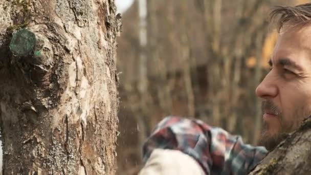 用枯死的树皮和园丁慢条斯理地清洁它的特写镜头老苹果树树干 在他的果园里 年轻长胡子的当地农民的脸 — 图库视频影像