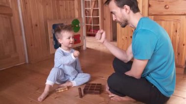Çocuk ve baba evde masa oyunu oynuyorlar. Oğlu ve babası taş kağıt makas oynuyorlar, çocuk kazanıyor. Karantina ve kendini izole etme sürecinde ebeveynler çocuklarıyla vakit geçirir. Aile etkinliği.