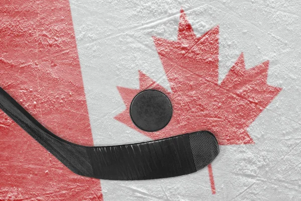 Puck de hockey con palo negro y bandera canadiense — Foto de Stock