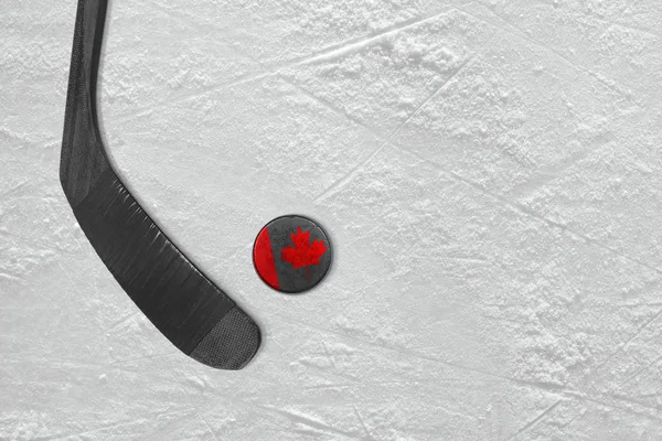 Canadian hockey stick and puck on the ice hockey rink — Stock Photo, Image