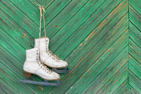 Oude schaatsen op een houten muur — Stockfoto
