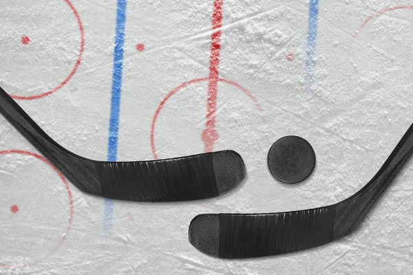 Två klubbor, puck och ett hockey fält med markeringar — Stockfoto