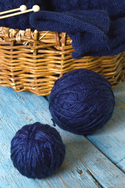 Рукоятки шерсти, вязальные иголки и синий вязаный шарф — стоковое фото