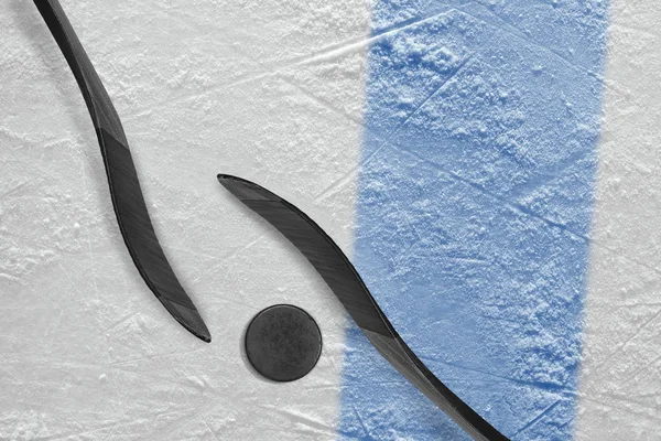 Deux bâtons de hockey, une rondelle et un fragment de l'arène de glace avec un — Photo