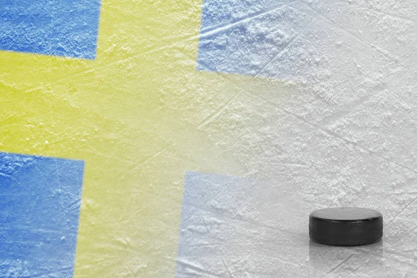 Eishockey-Puck und das Bild der schwedischen Flagge auf dem Eis — Stockfoto