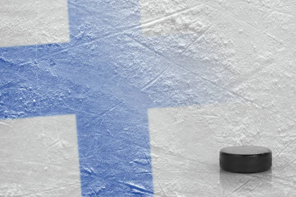 Disco de hóquei e a imagem da bandeira finlandesa no gelo — Fotografia de Stock