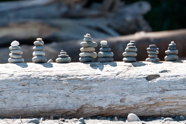 Group of stacked rocks on driftwood