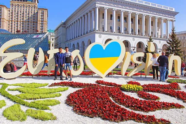 Неизвестные туристы возле части официального логотипа конкурса песни "Евровидение-2017" на Майдане Независимости ) — стоковое фото