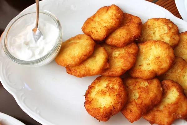 Tasty potato pancakes with sauce on white plate, closeup — Stock Photo, Image