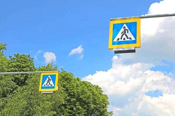 Дорожные знаки пешеходного перехода на фоне деревьев — стоковое фото