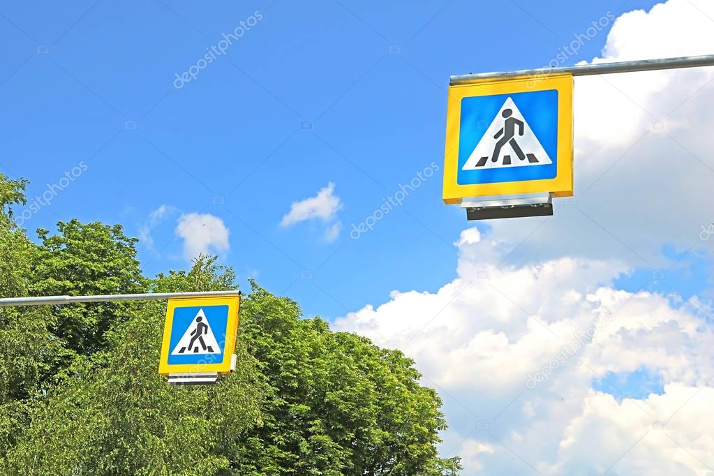 Road signs pedestrian crossing on background of trees