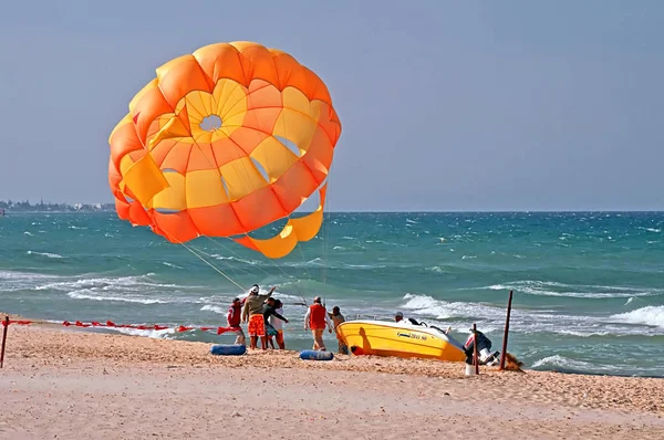 Kimliği belirsiz insanlar rüzgarlı hava paraşüt açmak çalışıyor