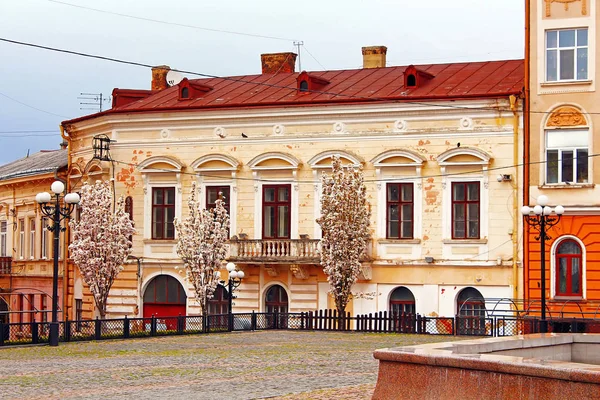 Antiguo edificio en la plaza Filarmónica, donde los turistas y los lugareños les gusta alimentar a las palomas, Chernivtsi, Ucrania —  Fotos de Stock