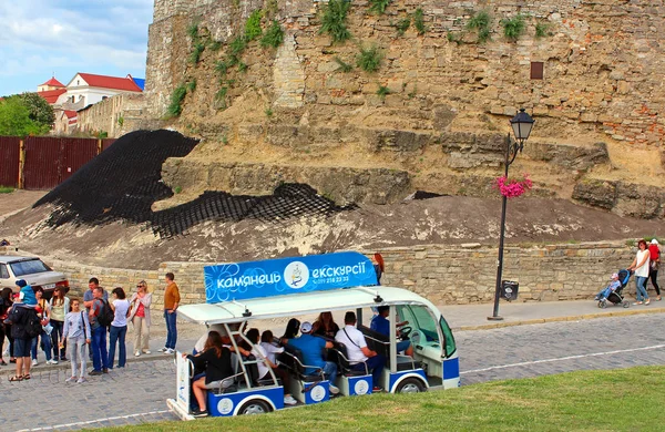 Touristenbus (in Bewegung) in der Nähe der Mauer des Kamianez-Podilskyi Schlosses. es ist eine ehemalige ruthenisch-litauische Burg und eine spätere dreiteilige polnische Festung in der historischen Stadt Kamianez-Podilskyi, Ukraine — Stockfoto