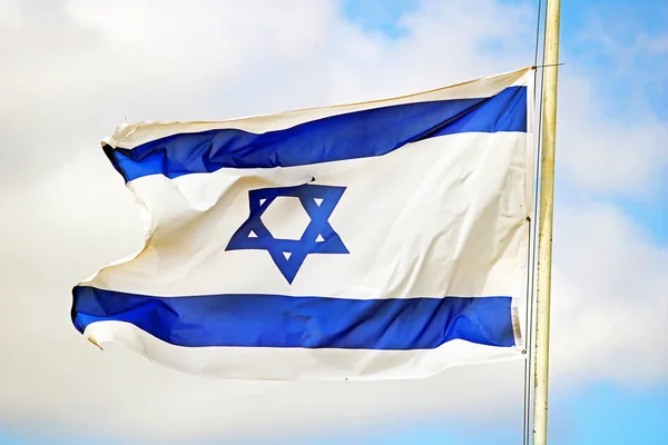 Izrael zászló zár-megjelöl szemcsésedik, háttérben a kék ég. Fehér és kék színek. Izrael zászló integet az ég ellen — Stock Fotó