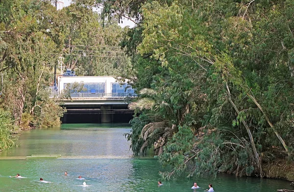 Pilger in weißen Gewändern stürzen sich auf den jordanischen Fluss (Yardenit)) — Stockfoto