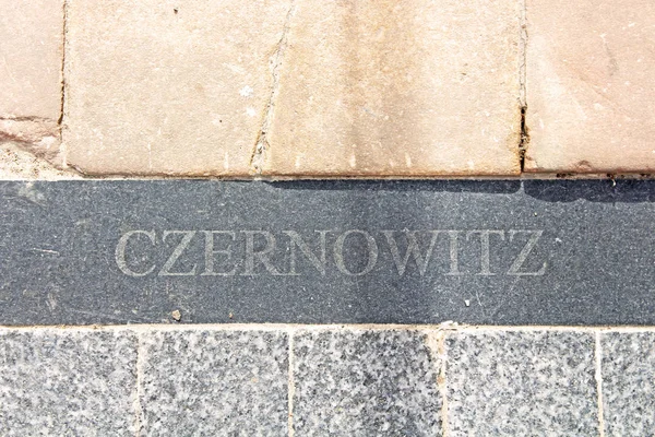 De naam van Tsjernivtsi stad is Duits (Czernowitz) in de plaat in het asfalt langs Olga Kobylianska Street, Tsjernivtsi, Oekraïne — Stockfoto