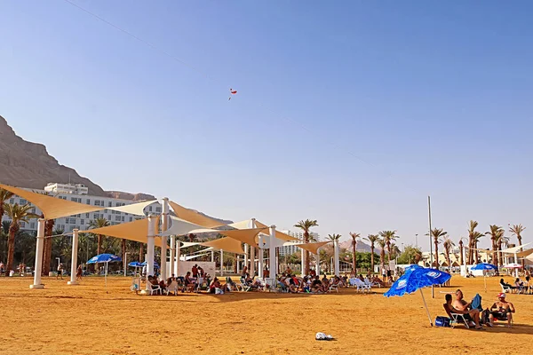 Férias e turistas descansam no resort Mar Morto no fundo de hotéis de luxo em Ein Bokek, Mar Morto, Israel — Fotografia de Stock