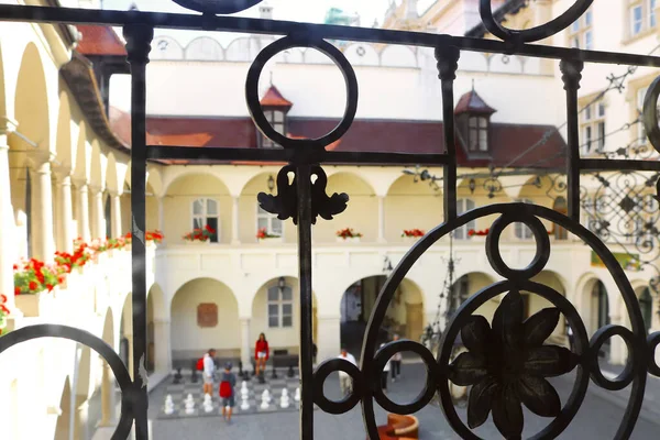 Bratislava, Slowakije - 03 september 2019: Wazig uitzicht op onbekende mensen spelen groot schaken op de binnenplaats van het stadhuis in het centrum van de oude stad. Uitzicht door de tralies. Selectieve focus — Stockfoto