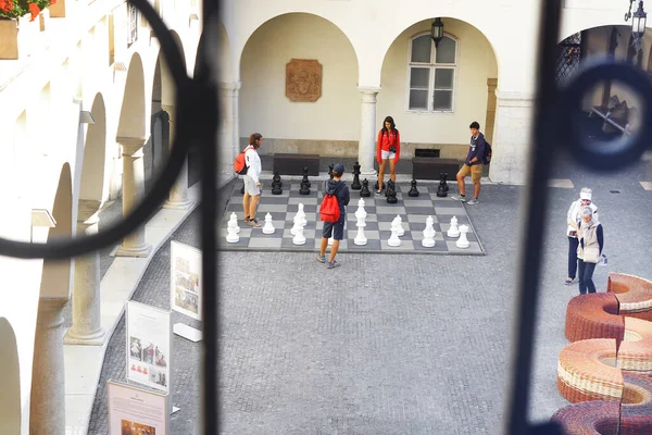 Bratislava, Slowakije - 03 september 2019: Onbekenden spelen groot schaak op de binnenplaats van het stadhuis in het centrum van de oude stad. Uitzicht door de tralies — Stockfoto