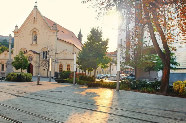 夕方には聖シュテファン教会、ブラチスラバ、スロバキア。太陽の光から舗装上の黄色のグレアや影 — ストック写真