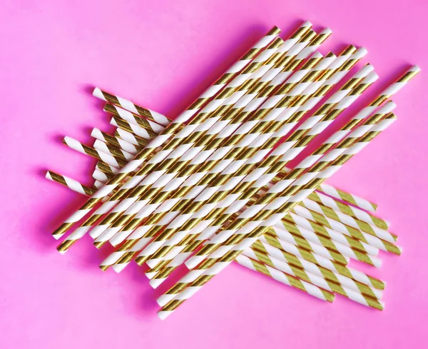 Top view of colorful paper disposable eco-friendly straws. Drinking straws with gold strips for party on pink background with copy space. Eco waste concept — Stock Photo, Image