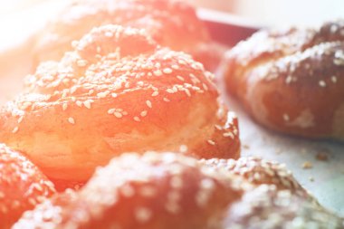 Sabahın erken saatlerinde susam tohumlu taze burulmuş çörekler. Sabah güneşi