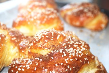 Sabahın erken saatlerinde susam tohumlu taze burulmuş çörekler. Sabah güneşi