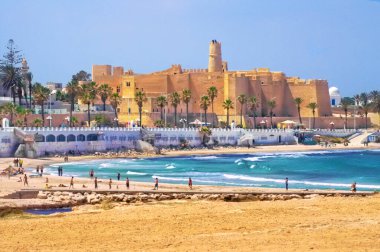 MONASTIR, TUNISIA - MAYIS 06, 2007: Dalgalar ve rahatlayan ve futbol oynayan insanlarla Akdeniz manzarası