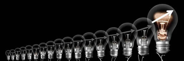 Glödlampor med piltillväxtkoncept — Stockfoto