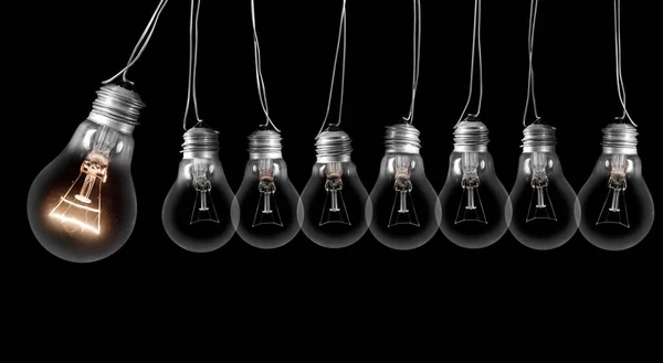 Група Темних Сяючих Лампочок Поспіль Ізольована Чорному Тлі Концепція Ідеї — стокове фото