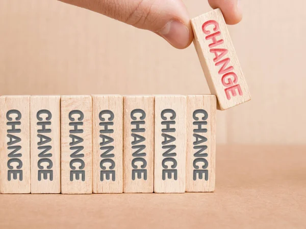 Wooden blocks with Chance and Change imprinted, one of them hold by a human hand. Concept of Motivation and Success.