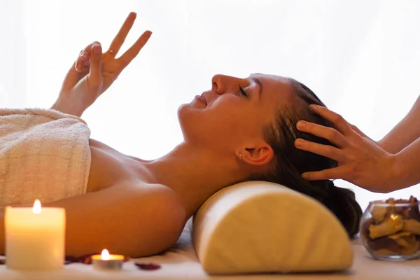 Woman enjoying massage, shows a sign of victory — Stock Photo, Image