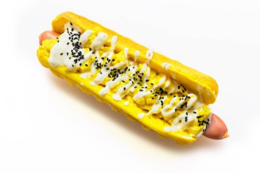 Beyaz arka plan üzerinde beyaz peynir sosu ve siyah kimyon tohumları ile sosisli sandviç