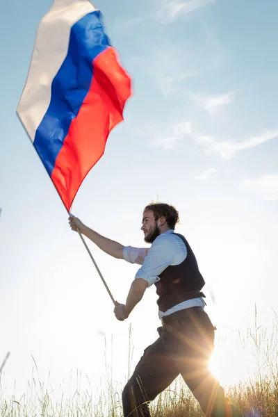 ロシア人の男性が屋外でロシアの旗を保持しています — ストック写真
