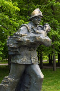 Saratov, Rusya - 26 Mayıs 2017: Görev sırasında hayatını kaybeden itfaiyeciler ve kurtarıcılar anıtı. İtfaiyeci kurtarılan çocuğu elinde tutuyor. Heykel Nisan 2014 Saratov Zafer Parkı.